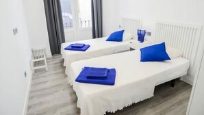 Une chambre d’hôtel avec deux lits, chacun agrémenté d’un oreiller bleu et d’un plateau bleu.