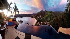 A swimming pool with a view of a beach and mountains.