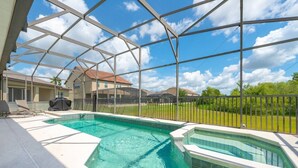 Piscina com cobertura de vidro, banheira de hidromassagem e área de churrasco coberta.