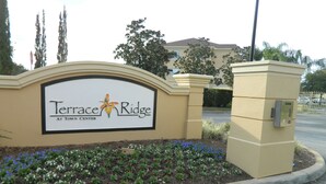 Señal de Terrace Ridge en Town Center con un jardín ajardinado al frente.