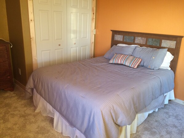 A bedroom with a bed, a wooden headboard, and a door. - Enjoy Our New House In Historic Leadville, including your pets. (Leadville)