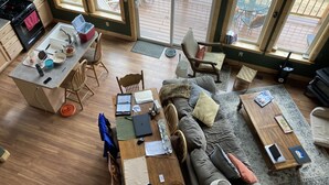 A cozy living room with a sofa, coffee table, and a dining area with chairs and a table.