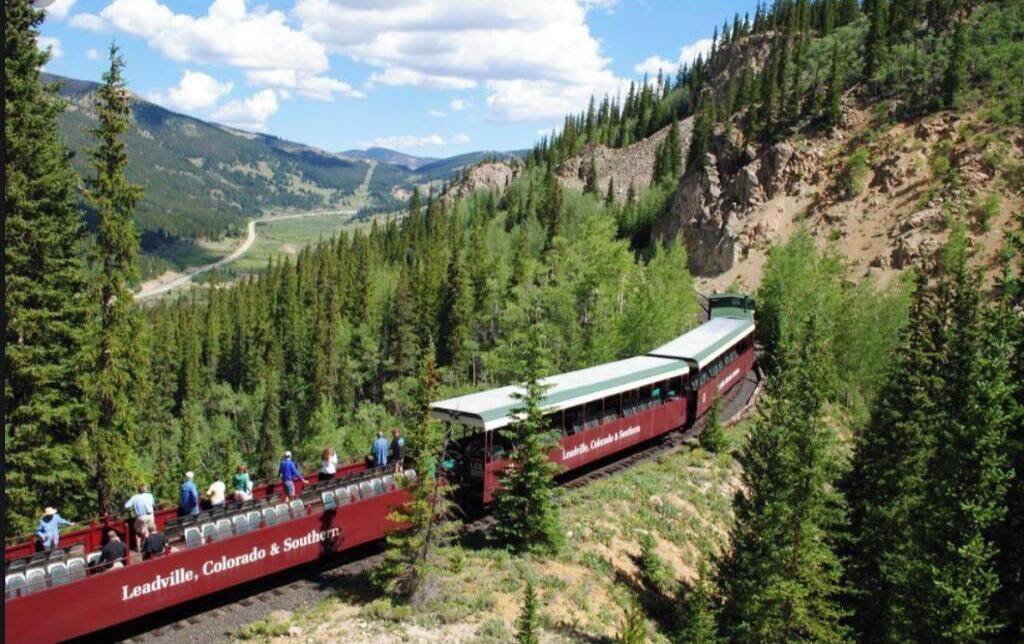 A train with passengers in a mountainous area.