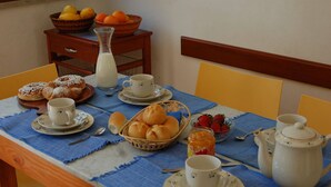A breakfast table set with pastries, fruit, and tea. - Charming Villa by the sea, wifi and cooking class free! (Termini Imerese)