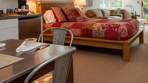 Een knus slaapkamer met een groot bed, een eettafel en een kitchenette.