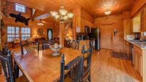 Ein Holzblockhaus-Interieur mit Essbereich, Küche und montiertem Tierkopf.