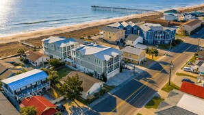 Uma área residencial costeira com casas, um cais e uma praia.