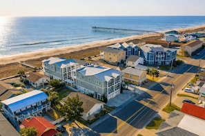 A coastal residential area with houses, a pier, and a beach.