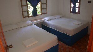 A small, clean room with two single beds, a small table, and a window with curtains. - Guicci Resort - Playa Corona beach  (San Carlos)