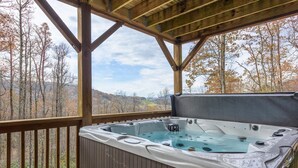 A hot tub on a wooden deck with a view of a forested landscape. - Mountain Cabin On Quiet Property (Boone)