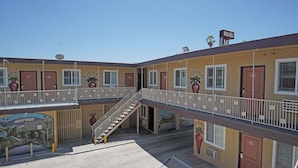 Un motel à plusieurs étages doté d’un escalier central, de balcons et d’une fresque représentant Hollywood Boulevard.