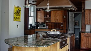Una cocina con encimera de granito, armarios de madera, microondas y estufa.