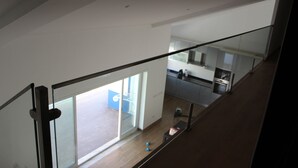 A modern kitchen with a large window, a dining area with a table and chairs, and a staircase leading to an upper floor. - Villa Terena with private pool (Terena)