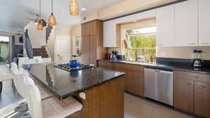 A modern kitchen with a central island, stainless steel appliances, and wooden cabinets. - A/C and 3 balconies to enjoy the sun. Beach gear and Traeger included (San Diego)