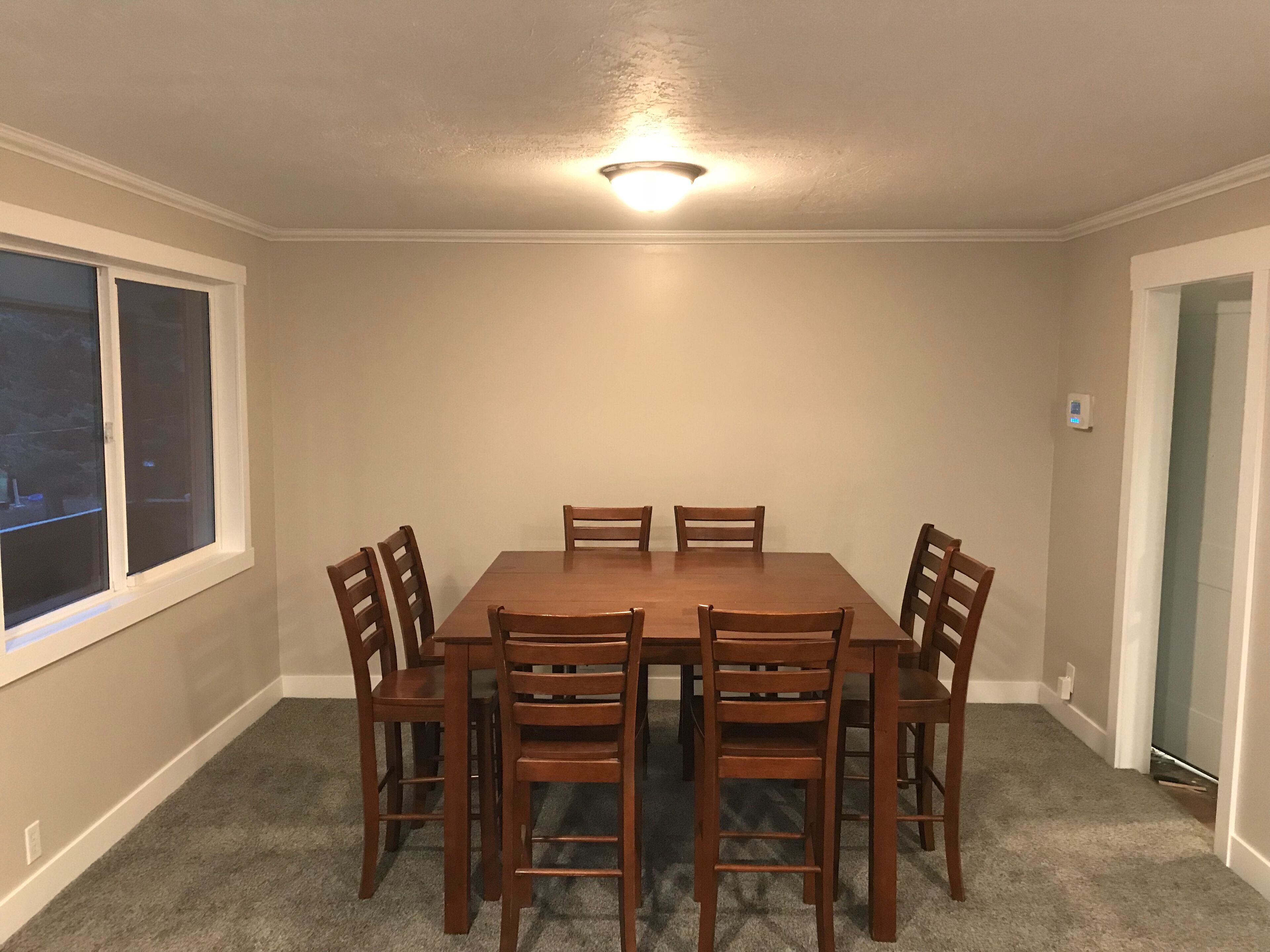 A dining room with a rectangular table and six wooden chairs.