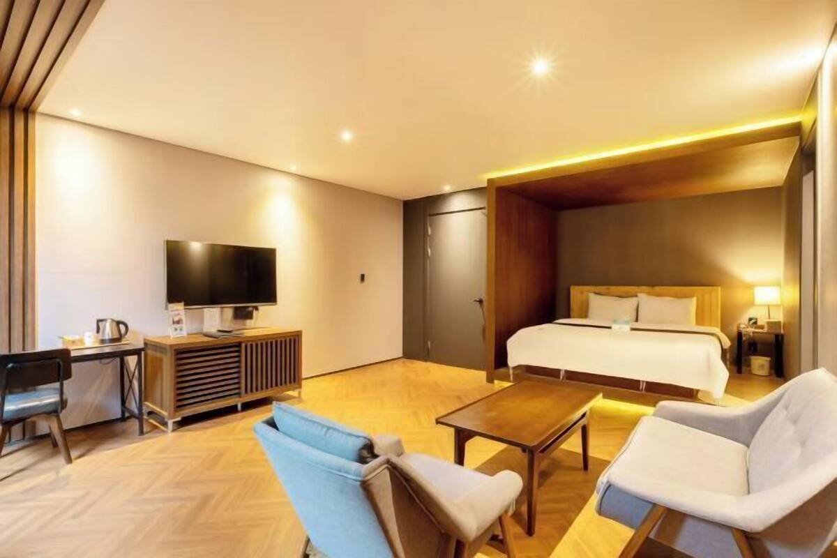 Une chambre d’hôtel équipée d’un lit, d’une télévision, d’un bureau et d’une table basse.