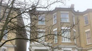 A multi-story building with a central entrance, a staircase leading to the front door, and a brick facade. - The studio - the heart of Primrose Hill (London)