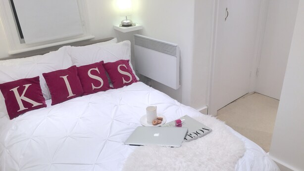 A neatly made bed with white bedding and two pillows with the letters "K" and "S" on them. - The studio - the heart of Primrose Hill (London)