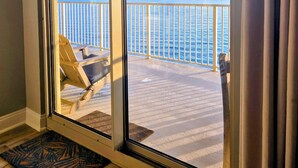 Ein Balkon mit Blick aufs Meer, ein Stuhl und eine Fußmatte.