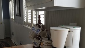 A kitchen with a coffee maker, a kettle, and a mug on the counter. - Very Clean, Well-appointed Cottage (Lakeside Marblehead)