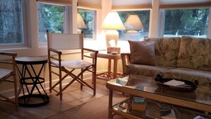 A cozy living room with a sofa, a coffee table, a chair, and a lamp. - Very Clean, Well-appointed Cottage (Lakeside Marblehead)