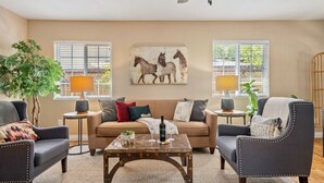 A living room with a sofa, two armchairs, a coffee table, and a painting of horses on the wall. - Discover the Perfect Wine Country Getaway 2Bed 2Bath (Paso Robles)