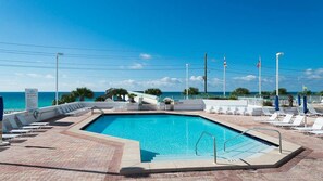 Relax by the oceanfront pool surrounded by lounge chairs and umbrellas.