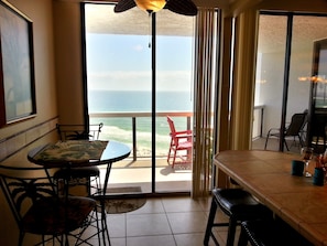 Enjoy ocean views from the balcony with a red chair and small table.