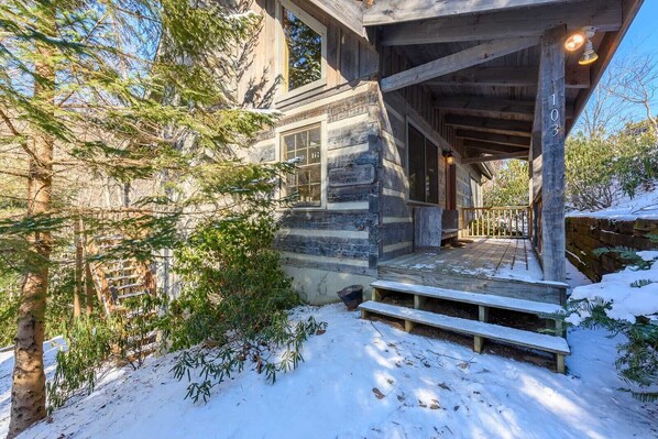 A rustic cabin with a wooden porch, a stone foundation, and a snow-covered landscape. - Pet-Friendly Cabin in Seven Devils (Seven Devils)