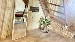 A wooden interior with a sloped ceiling, a mirrored wall, and a small plant. - Hunter's Cabin PR (Cabo Rojo)