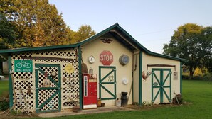 A small building with a stop sign, a bike route sign, and a rooster mural. -  A cozy cottage located 4 miles from Leiper's Fork in Williamson County TN (Thompson's Station)