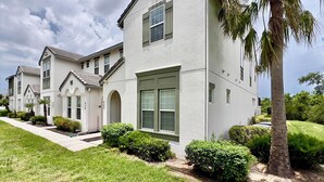 A row of modern two-story houses with a uniform architectural style, featuring large windows and a well-maintained lawn. - Festive Family Fun! Resort Close 2 Disney! Private Pool! 422 (Davenport)