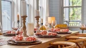 A dining table set with candles, glasses, and patterned napkins.