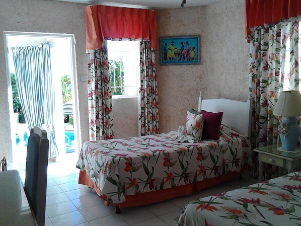 A bedroom with a bed, a nightstand, a lamp, and a painting on the wall.