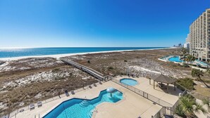 A resort with a pool area, a beach, and a boardwalk.