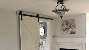 Une chambre à coucher comprenant un lit, une porte coulissante, une cheminée et un luminaire au plafond.