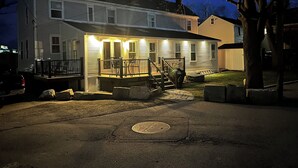 Une maison à deux étages avec un porche à l’avant, un escalier menant au deuxième étage et un garage.