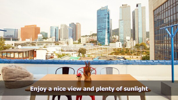 A cityscape view from a balcony with a table and chairs, and a decorative vase. - Ur Seoul Home (Seoul)