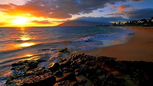 A beach with rocky foreground, calm sea, and a sunset. - Spectacular 3rd Row Villa at Ho'olei with Ocean Views (Kihei)
