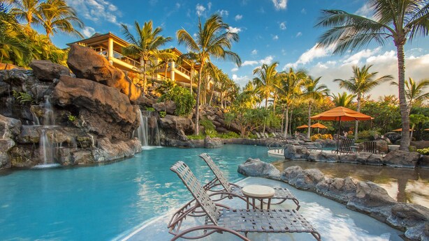 A resort pool with lounge chairs, a waterfall, and palm trees. - Spectacular 3rd Row Villa at Ho'olei with Ocean Views (Kihei)