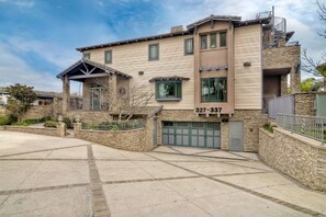 Ein zweistöckiges Gebäude mit einer Stein-Fassade, einer Garage und einem Balkon.