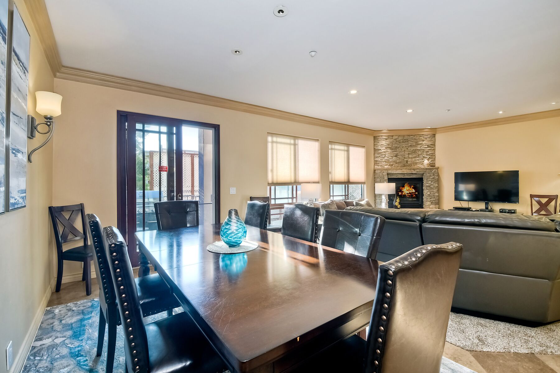 A spacious living room with a dining area, a fireplace, and a television.