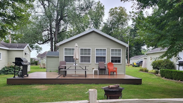 A small house with a deck, a grill, and outdoor furniture. - Gun Lake Cottage shared lake frontage, 7 Miles to Casino, Volleyball Playgrounds (Wayland)