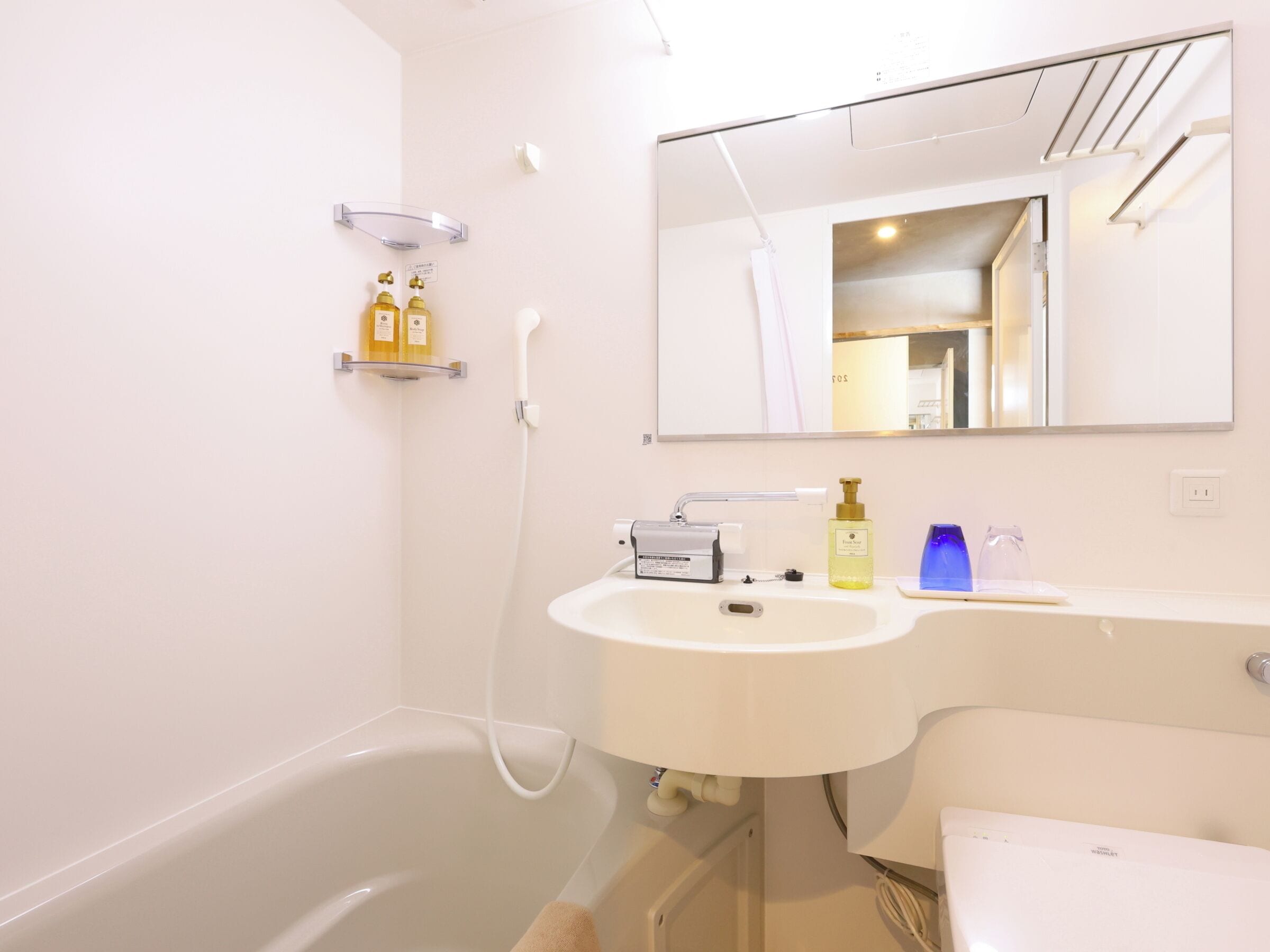 Ein Badezimmer mit Badewanne, Waschbecken, Spiegel und Duschkopf.