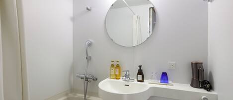 Een badkamer met een bad, wastafel, spiegel en toiletartikelen.