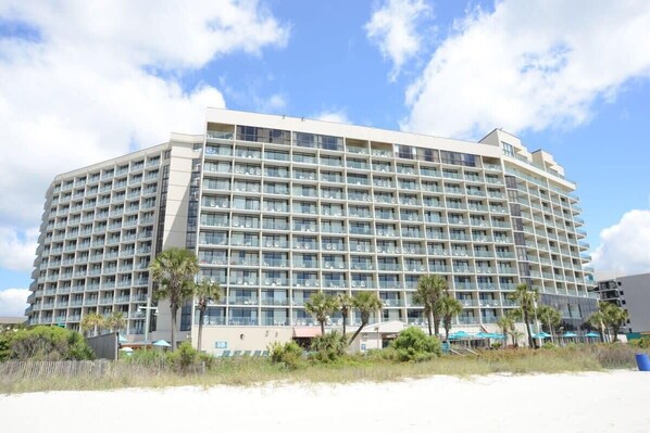Un grand hôtel à plusieurs étages, doté d’un design moderne, de nombreux balcons et situé en bord de mer.