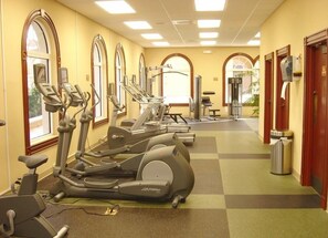 A gym with treadmills, exercise bikes, and a weight bench.