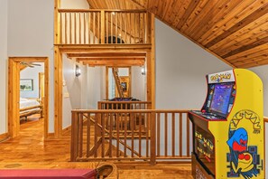 A multi-level wooden interior with a Pac-Man arcade machine. - 10 Min to Banner Elk | Sleeps 19 | Hot Tub, Sauna, Movie Theater & Mountain Views (Banner Elk)