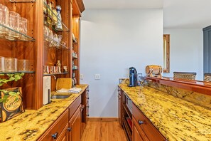 A kitchen with wooden cabinets, a granite countertop, and a coffee maker. - 10 Min to Banner Elk | Sleeps 19 | Hot Tub, Sauna, Movie Theater & Mountain Views (Banner Elk)