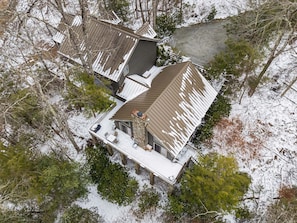 Una casa de varios pisos con techo nevado y un área de terraza.